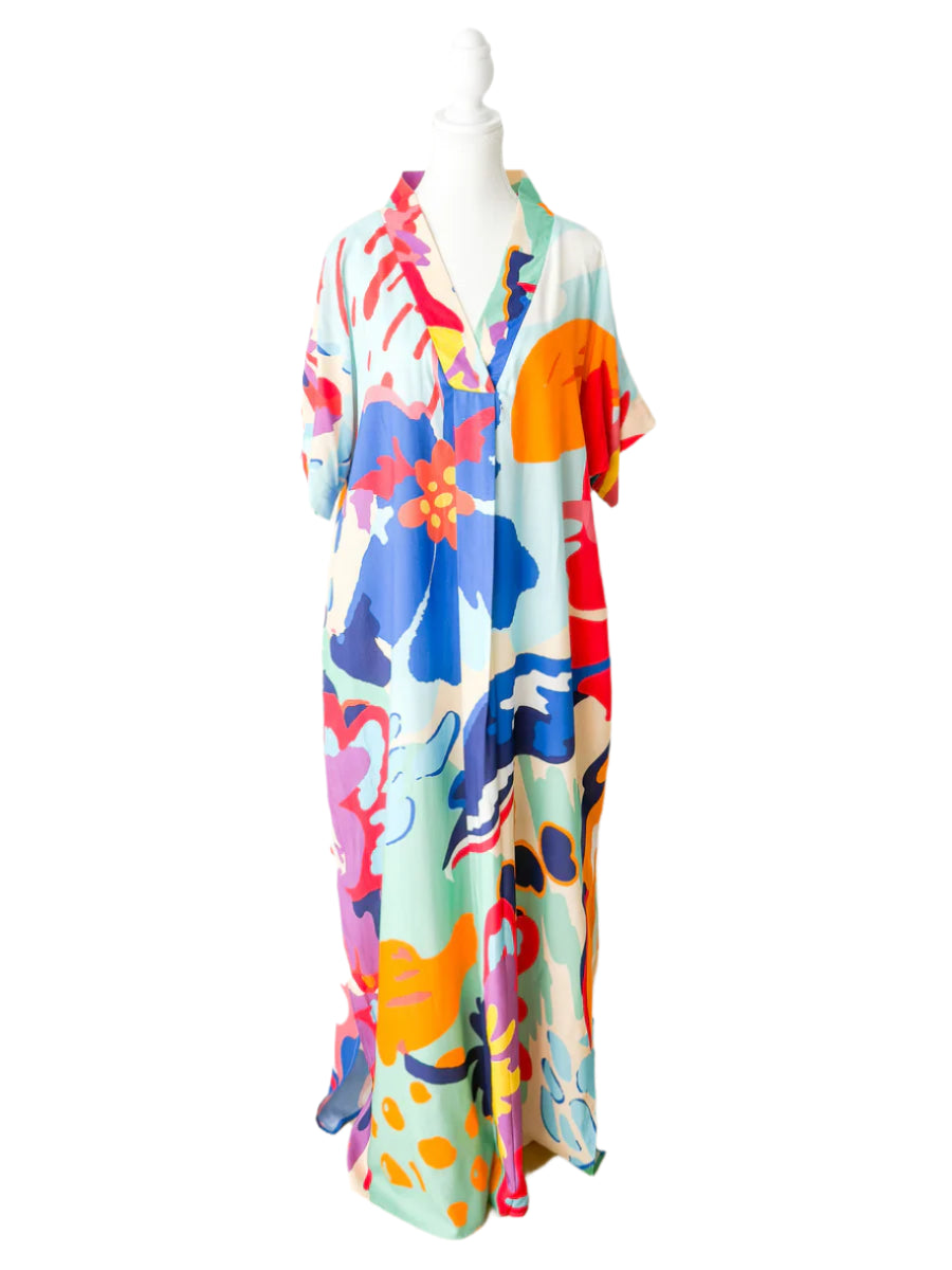 Colorful abstract patterned dress on a mannequin against a white background