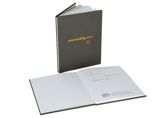 Open book with 'commanding space' text on a white background
